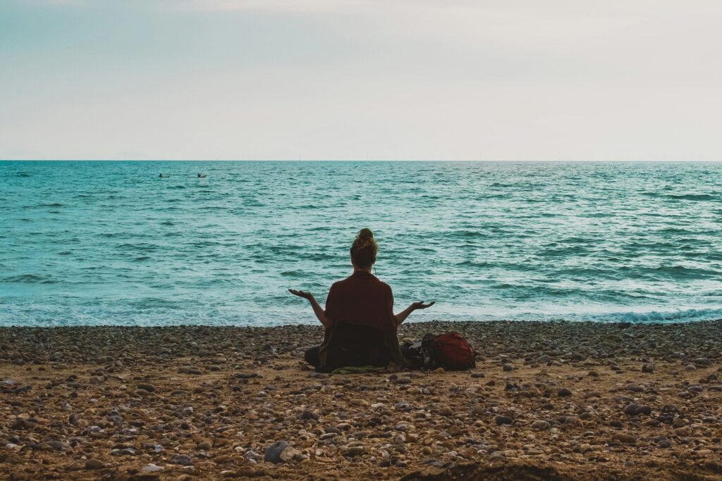 A person doing a gentle stretch outdoors, representing the calm, regulated movement that helps retrain a nervous system on high alert