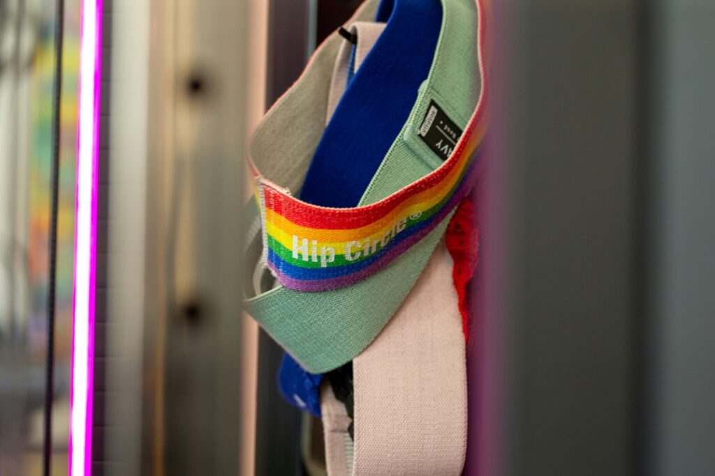 Rainbow-striped resistance bands hanging in a gym, representing accessible strength training tools for every body