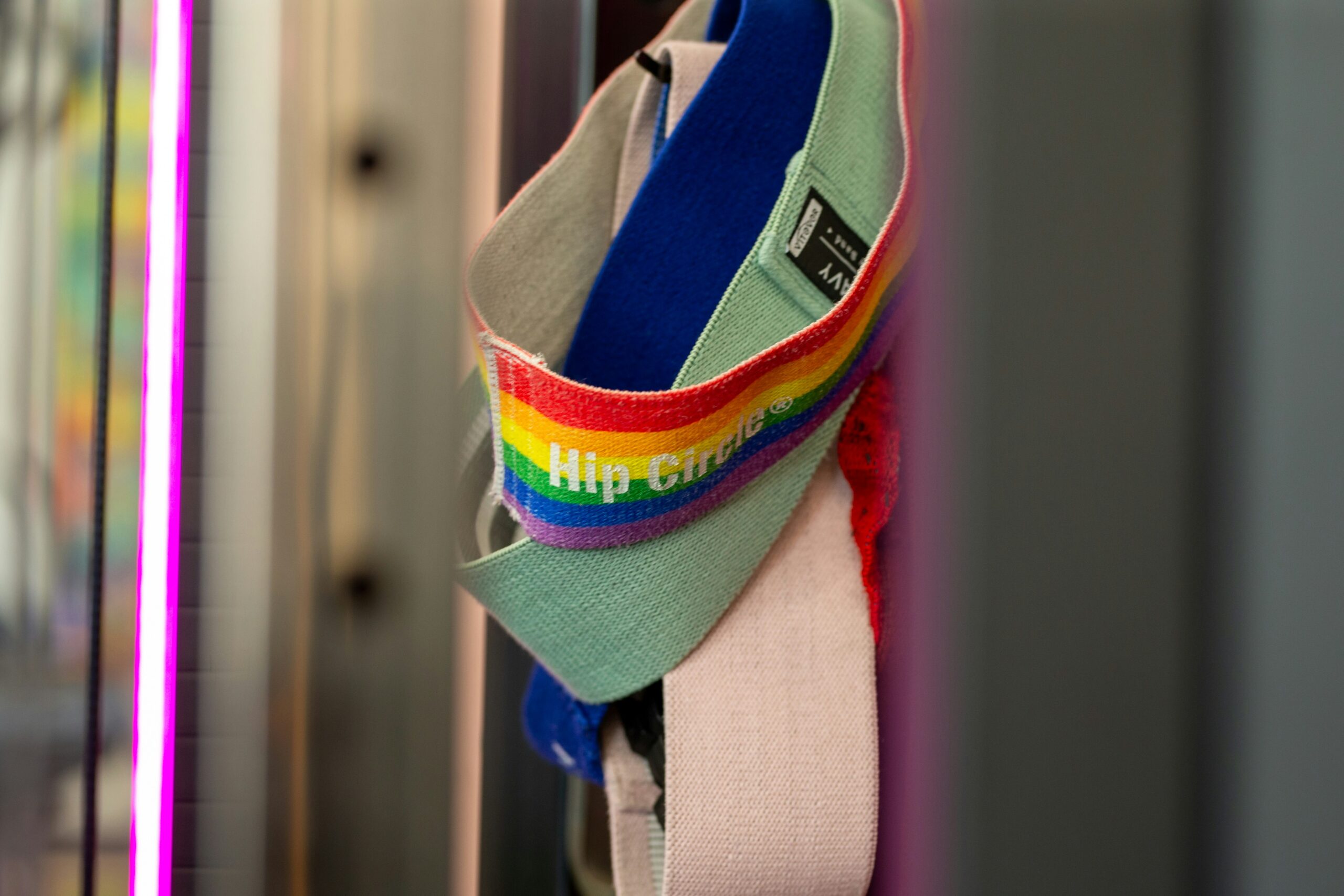 Rainbow-striped resistance bands hanging in a gym, representing accessible strength training tools for every body