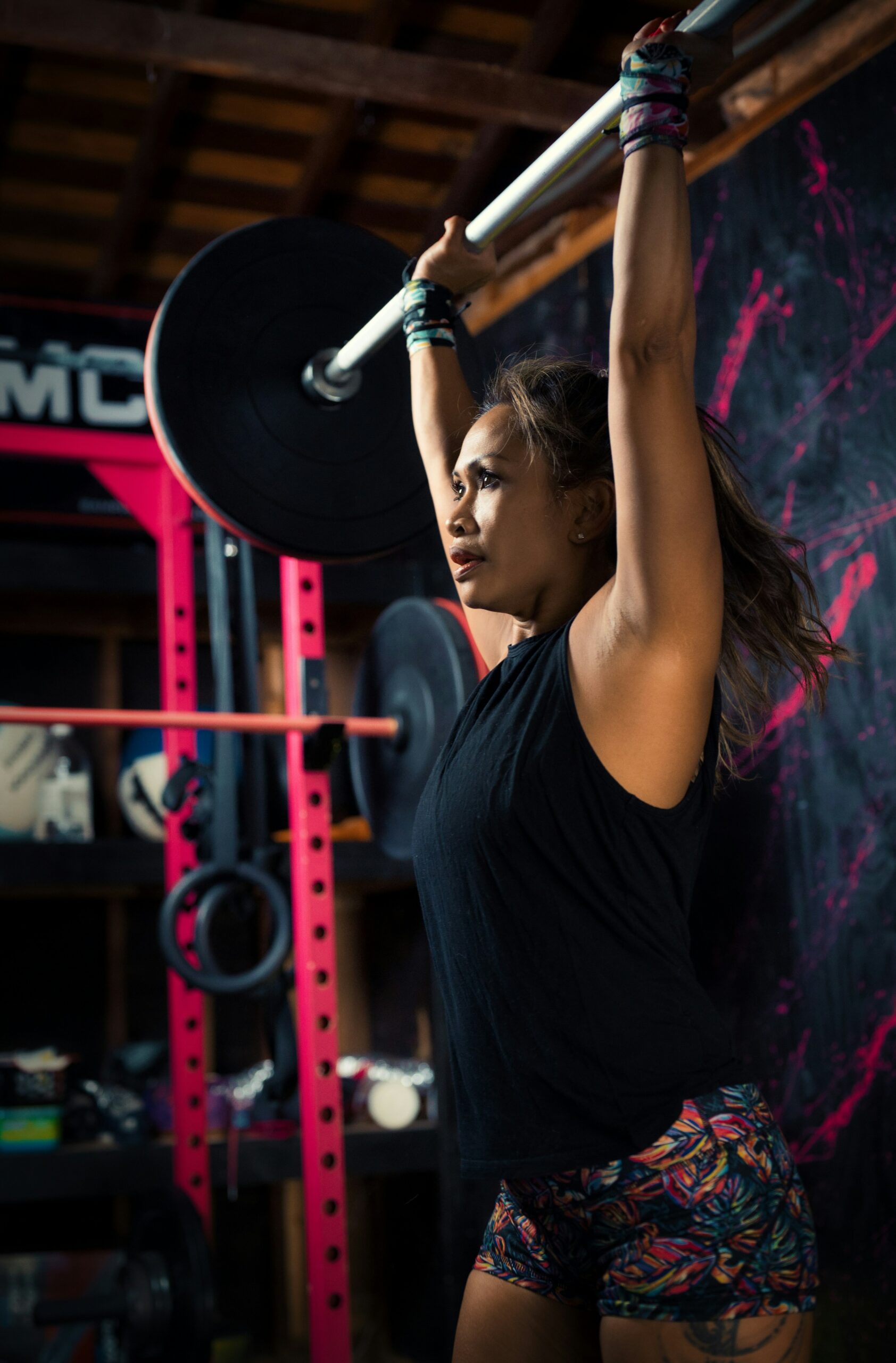 A person gripping a black dumbbell mid-workout, hand and forearm in focus