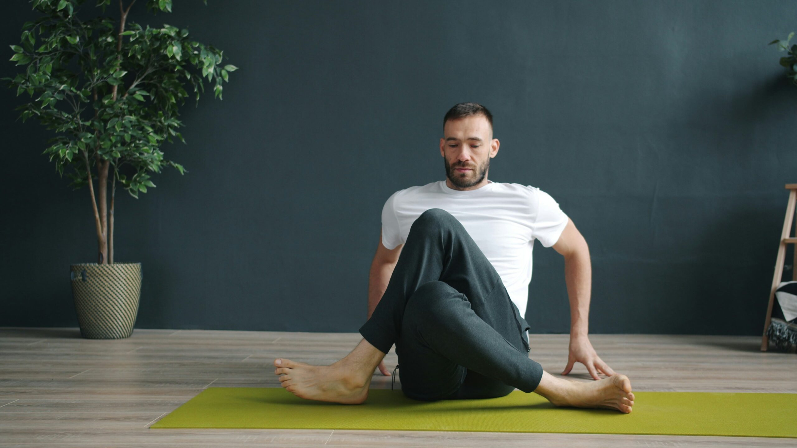 A person gently twisting their torso on a yoga mat, representing guided movement for low back pain recovery
